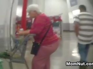 Liels vecmāmiņa pakaļa spied par pie the veikals